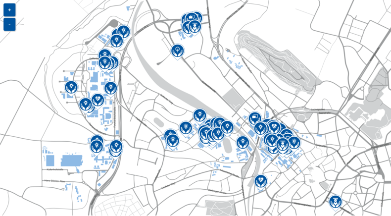 Abgebildet ist der stilisierte Campusplan der RWTH mit den großen Arealen Mitte, Hörn und Melaten. Vereinzelt sind Markierungen gesetzt. Diese sind in Form von Standort-Pins und haben jeweils unterschiedliche Icons.  Alle Icons sind aus zwei offenen Händen unten und einem Symbol aufgebaut. Es gibt fünf unterschiedliche Symbole:  Eine Glühbirne – sie steht für das Handlungsfeld „Forschung“. Eine Person mit Doktorhut – steht für den Bereich „Studium und Lehre“. Eine Blume, bei welcher die Blüte ein Zahnrad darstellt steht für das Handlungsfeld „Betrieb“.  Für Bereich „Governance“ steht ein Symbol zweier sich schneidender Sprechblasen.  Das Symbol zweier sich schüttelnder Hände, die eine Herzform bilden, symbolisieren das Handlungsfeld „Internationales – Soziales – Gesellschaft“.   Jede Markierung steht für ein Projekt, eine Ansprechperson, eine Initiative oder ähnliches, welche sich mit einem spezifischen Nachhaltigkeitsthema befasst. Die Pins sind bei hinterlegten Adressen angesiedelt.